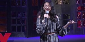 “Ishita Katyal delivering a TED talk, symbolizing vibrant living, purpose, and impact at a young age.”