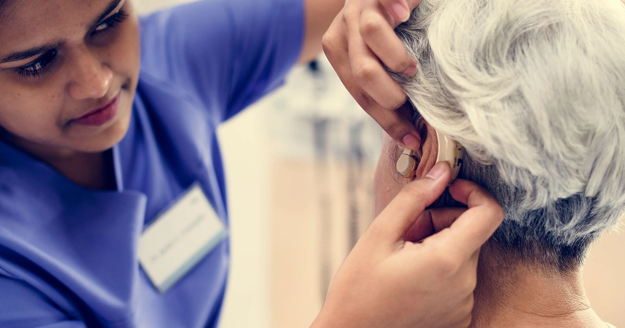 Senior gently touching their ear, symbolizing awareness and care for hearing health.